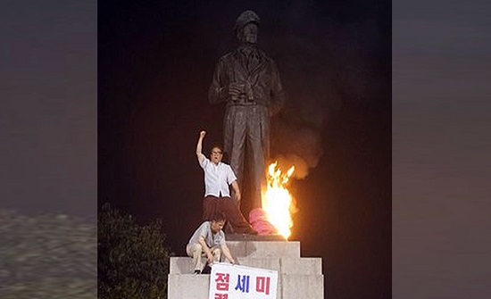 반미 성향의 진보단체 평화협정본부 회원들이 지난 27일 새벽 맥아더 장군 동상에 불을 지르고 있다. ⓒ KBS 화면 캡처