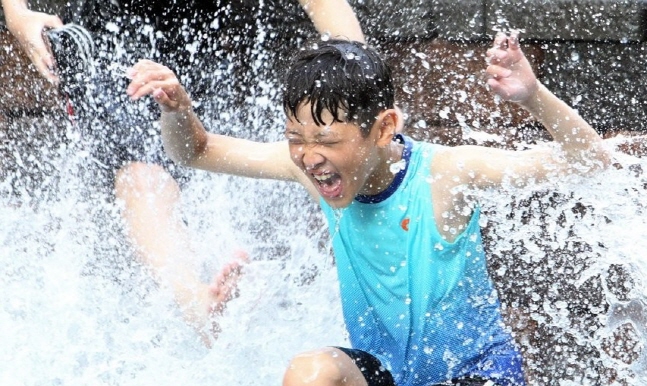 지난 13일 전북 전주시 덕진구 한 아파트에서 아이가 분수대에서 물놀이를 즐기고 있다. ⓒ 연합뉴스 