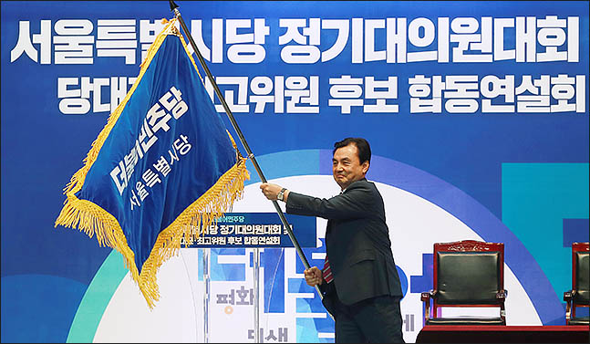 안규백 더불어민주당 의원이 18일 서울 장충체육관에서 열린 서울시당 정기대의원대회에서 신임 서울시당위원장으로 선출된 직후, 당기를 건네받아 휘날리고 있다. ⓒ데일리안 류영주 기자