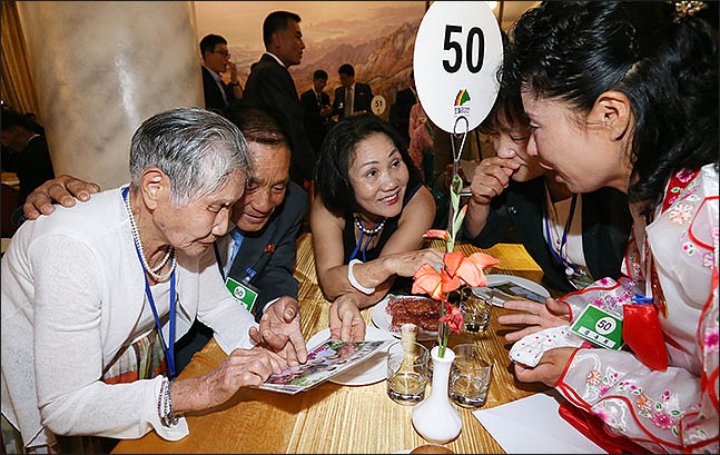 제21차 이산가족 상봉행사 첫날인 20일 오후 북한 금강산호텔에서 진행된 단체상봉에서 이금섬(92) 할머니가 아들 리상철(71)씨와 사진을 보고 있다. ⓒ사진공동취재단