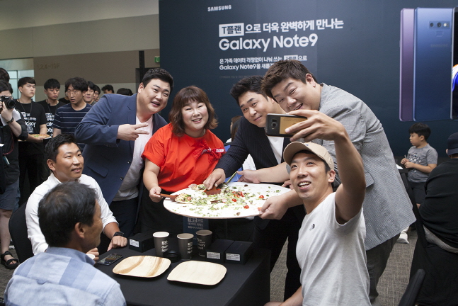 방송인 김준현 씨, 김민경 씨, 문세윤 씨, 유민상 씨(첫번째 사진 왼쪽부터)가 'T플랜'의 넉넉한 데이터를 상징하는 지름 60cm의 대형 피자를 고객들에게 나눠주고 있다. ⓒ SKT