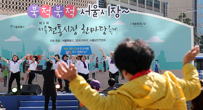 서울 전통시장 한마당 축제에서 한 시민이 공연을 보며 춤을 추고 있다. ⓒ연합뉴스 자료사진