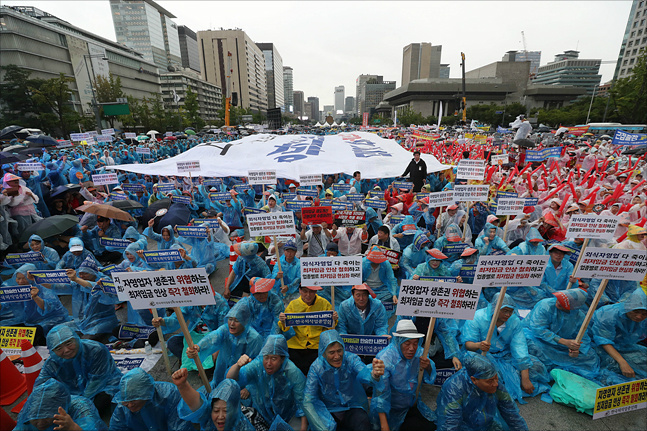전국의 소상공인·자영업자 2만여 명이 지난 29일 오후 호우특보가 발령된 서울 광화문광장에 모여 최저임금 인상 철회와 업종별 차등 적용을 요구하고 있다. ⓒ데일리안 홍금표 기자