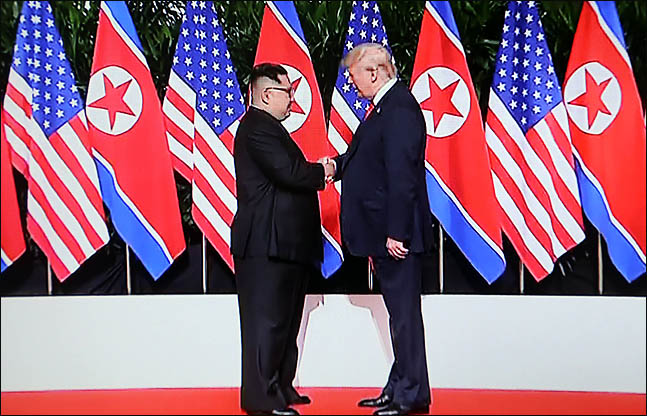 도널드 트럼프 미국 대통령과 김정은 북한 국무위원장이 12일 싱가포르 카펠라 호텔에서 역사적인 첫 북미정상회담에 앞서 악수를 하고 있다./jtbc 화면촬영 ⓒ데일리안