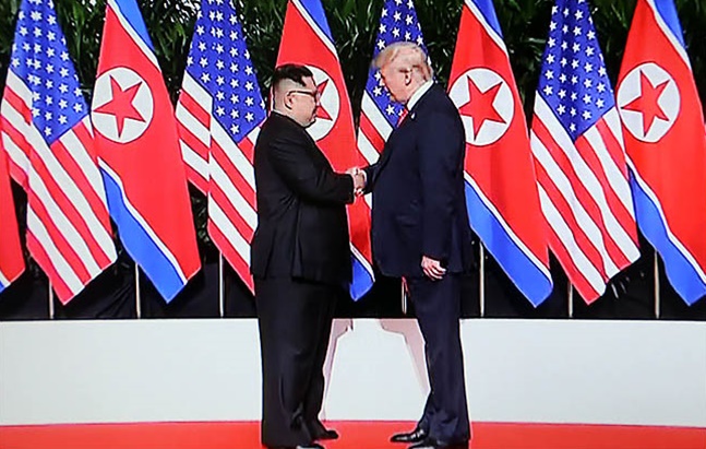 도널드 트럼프 미국 대통령과 김정은 북한 국무위원장이 지난 6월 12일 싱가포르 카펠라 호텔에서 역사적인 첫 북미정상회담에 앞서 악수를 하고 있다./jtbc 화면촬영 ⓒ데일리안 
