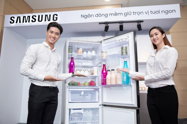 삼성전자 남녀 모델이 13일(현지시간) 베트남 호치민 소재 가전복합단지에서 상냉장·하냉동 냉장고 신제품을 소개하고 있다.ⓒ삼성전자