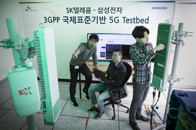 SK텔레콤과 삼성전자 연구원들이 15일 SK텔레콤 분당사옥 5G 테스트베드에서 3.5GHz 대역 5G상용 장비로 퍼스트콜에 성공했다. ⓒ SKT