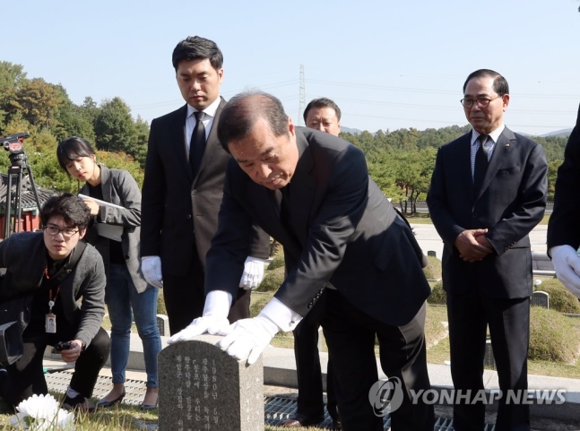 김병준 자유한국당 비상대책위원장이 17일 광주 망월동 5·18 묘역을 찾아 김의기 열사의 묘비를 쓰다듬고 있다. ⓒ연합뉴스
