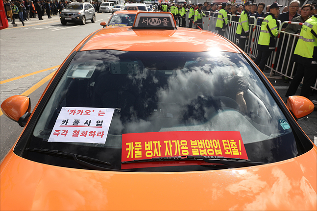 카카오 카풀 서비스 사업에 반대하며 '택시 생존권 사수 결의대회'가 열린 18일 서울 광화문광장을 지나는 택시에 카카오 카풀 서비스를 반대하는 문구가 부착되어 있다. ⓒ데일리안 홍금표 기자 