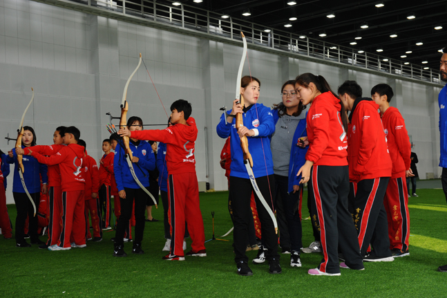 현대모비스 여자 양궁단 선수들이 중국 톈진 지역 초·중학교 어린이들을 대상으로 한 어린이 양궁 교실에서 활 쏘는 법을 지도하고 있다.ⓒ현대모비스