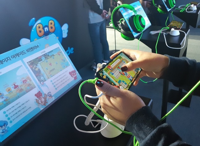 부산 벡스코에서 열린 '지스타 2018'에서 LG전자의 스마트폰으로 넥슨의 모바일 게임을 실행하고 있는 모습.ⓒ데일리안 유수정 기자
