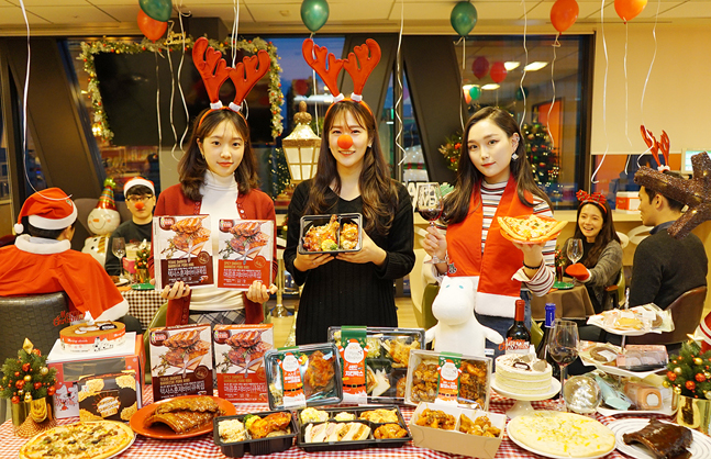 세븐일레븐은 지난 5일 오후 서울 중구 수표동 소재 본사 내 직원 휴게실 행복충전소에서 연말 시즌을 맞아 임직원 파티를 열었다. 파티에 참석한 세븐일레븐 직원들이 세븐일레븐 파티 먹거리 상품을 선보이고 있다.ⓒ세븐일레븐