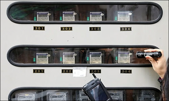 정부가 여름철마다 뜨거운 감자로 떠오르는 ‘주택용 전기요금 누진제’에 메스를 들었다. 사진은 한 전기검침원이 서울 주택가에서 전기계량기를 확인하는 모습.ⓒ연합뉴스