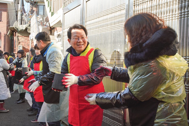 지난 14일 서대문구 홍제동에서 NH농협금융지주 김광수 회장(오른쪽 두번째)과 임직원들이 연탄을 배달하고 있다.ⓒNH농협금융지주