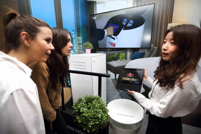 25일(현지시간) KT 전시관 내 5G AI 호텔 로봇 존에서 관람객이 AI 호텔 로봇 서비스를 체험하고 있다. ⓒ KT