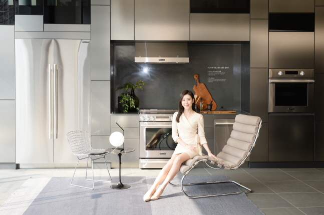 LG전자 모델이 놀의 대표 제품 중 하나인 엠알 체어(﻿MR Chaise)에 앉아 가전과 가구가 조화를 이루는 주방 공간을 소개하고 있다.ⓒLG전자
