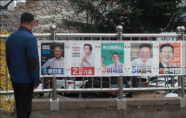 4.3 재보궐 선거 공식 선거운동 첫날인 21일 오후 창원 성산구의 한 아파트에 붙은 벽보를 유권자가 보고 있다. ⓒ데일리안 류영주 기자