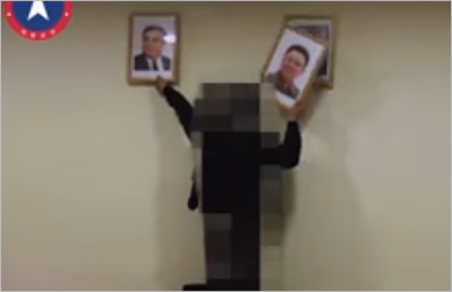 자유조선 조직원이 벽에 걸린 김일성·김정일 초상화를 폐기하고 있다. ⓒ자유조선 