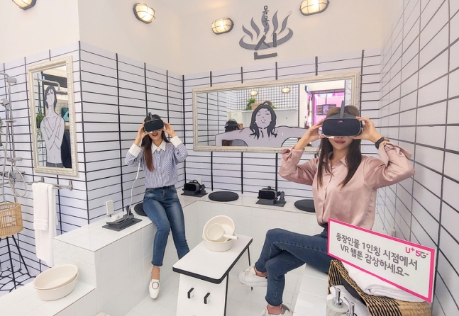 LG유플러스 모델들이 서울 강남역 근처의 ‘일상로 5G길’에서 이용자들이 가상현실(VR) 웹툰 서비스를 이용해보고 있다. ⓒ LGU+ 