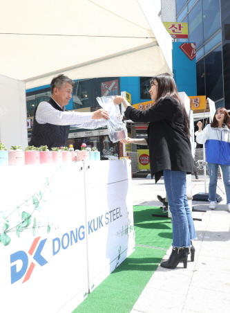 장세욱 동국제강 부회장이 철의 친환경성을 홍보하기 위한 ‘그린 캠페인’ 일환으로 임직원들과 15일 서울 마포에서 한 시민에게 철로 만든 미니 화분을 나눠주고 있다.ⓒ동국제강