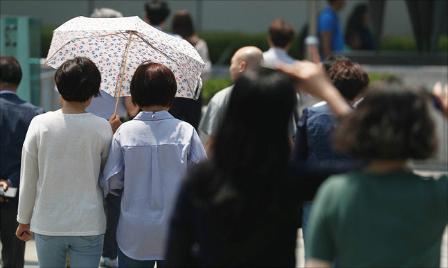 서울에서 올해 첫 폭염주의보가 발효된 24일 오후 서울 종로구 세종대로 인근에서 양산을 쓴 시민들이 길을 지나고 있다. ⓒ데일리안 홍금표 기자