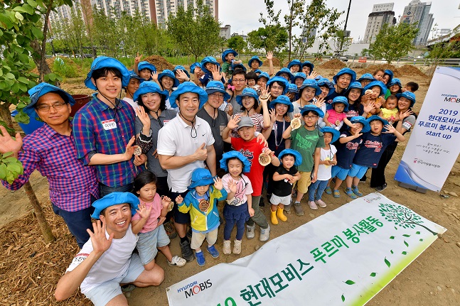 현대모비스 직원 가족 봉사단이 한강공원 이촌지구에서 ‘현대모비스 정원’을 조성하기 위해 팽나무와 갈참나무 묘목 100여 주를 심고 있다. ⓒ현대모비스