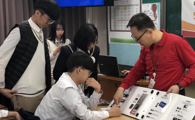 SK하이닉스 전임강사(오른쪽)가 경기도 이천 부원고등학교에서 개최된 'SKHU 행복교실'에서 학생들에게 다양한 반도체 제품을 보여주며 설명하고 있다.ⓒSK하이닉스