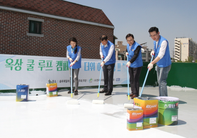 자원봉사자들이 지난달 31일 서울 송파제일어린이집 옥상에서 KCC 고기능성 차열 페인트를 도장하며 쿨루프 작업을 하고 있다.ⓒKCC