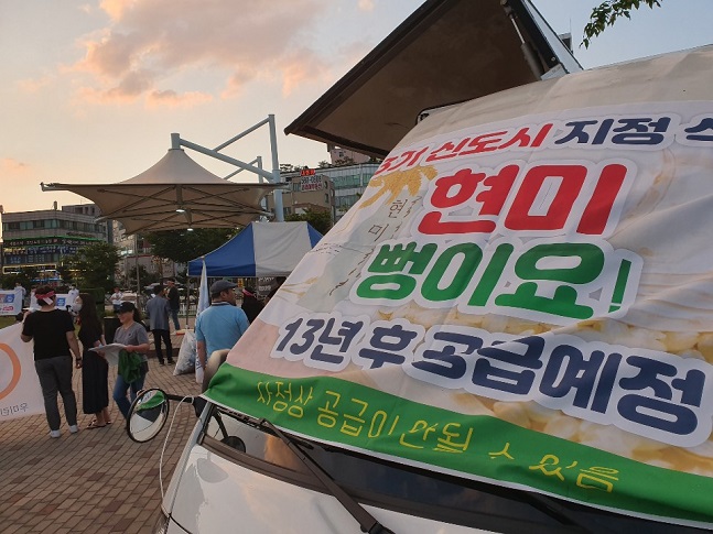 지난 15일 인천 서구 완정역 광장에서 열린 3기 신도시 반대집회에서 현미로 만든 뻥튀기를 제공하는 '현미 뻥튀기 행사' 퍼포먼스를 진행 중이다. ⓒ검단신도시입주자연합회