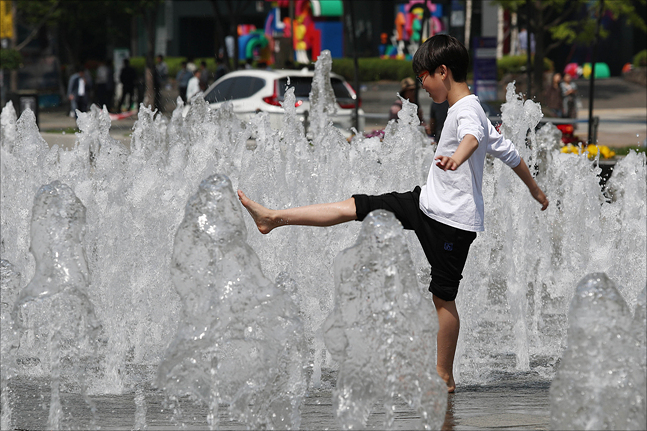 지난달 서울 세종대로 광화문광장에서 한 어린이가 분수대에서 물놀이를 하며 더위를 식히고 있다. ⓒ데일리안 홍금표 기자