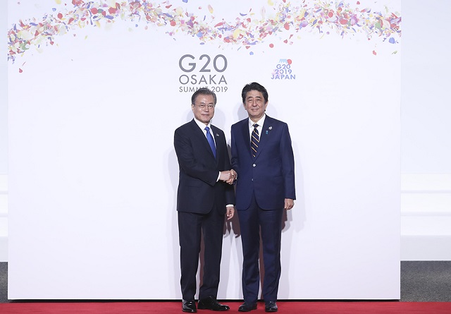 문재인 대통령이 6월 28일 일본 오사카 국제컨벤션센터 인텍스오사카에서 열린 G20 정상회의 공식환영식에서 아베 신조 일본 총리와 악수하고 있다. ⓒ청와대