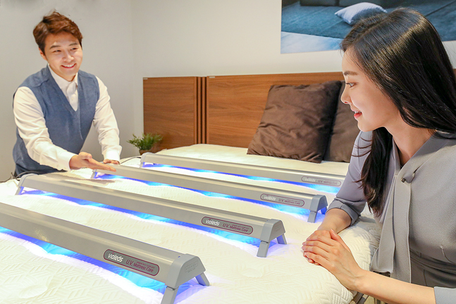 현대렌탈케어 직원과 모델이 고정형 LED 살균기를 사용해 살균 서비스를 제공하고 있는 모습.ⓒ현대렌탈케어