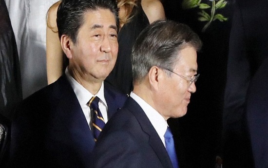 6월 28일 일본 오사카에서 열린 주요20개국(G20) 회의에서 단체 사진 촬영을 앞두고 문재인 대통령이 아베 신조 일본 총리 앞을 지나고 있다. ⓒ마이니치 신문