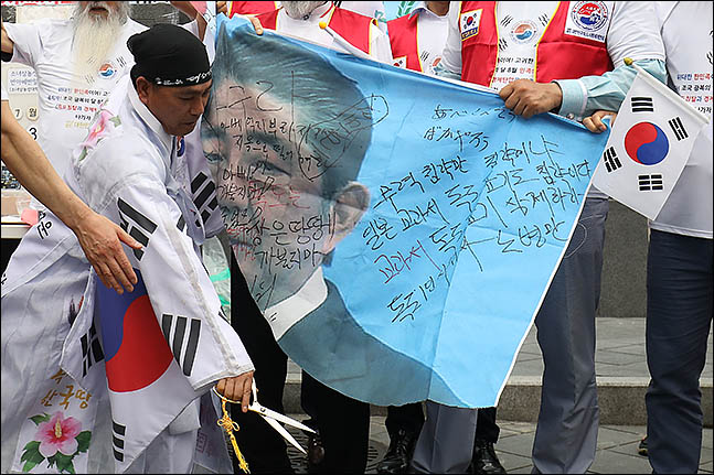 독도사랑세계연대 회원들이 23일 오후 서울 종로구 옛 일본대사관 앞에서 열린 일본정부 규탄대회에서 아베 총리의 사진을 찢고 있다. ⓒ데일리안 류영주 기자