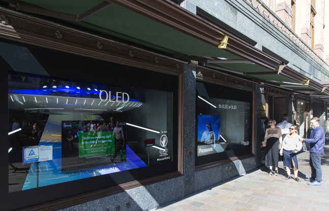 LG디스플레이가 영국 런던 해롯백화점 1층 쇼윈도에 전시한 글로벌업체들의 OLED TV를 방문객들이 관람하고 있다.ⓒLG디스플레이
