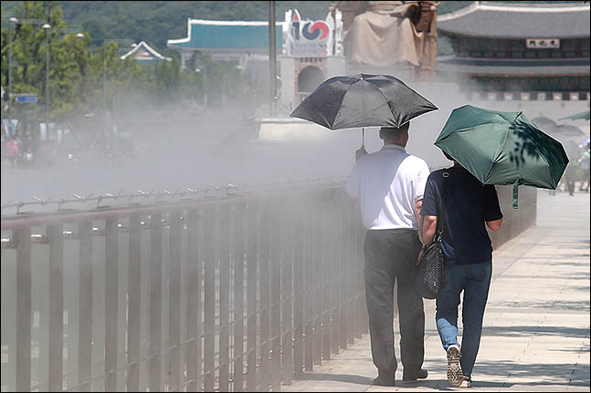 서울 종로구 광화문 광장 쿨스팟에 시민들이 더위를 식히며 지나가고 있다. ⓒ데일리안 류영주 기자
