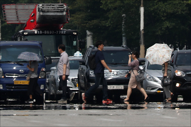 올여름 폭염이 절정에 이르며 전국 대부분의 지역에 폭염 경보가 발효된 가운데 5일 오후 서울 영등포구 여의도 환승센터에서 시민들이 길을 지나는 가운데 아지랑이 피어오르고 있다. ⓒ데일리안 홍금표 기자