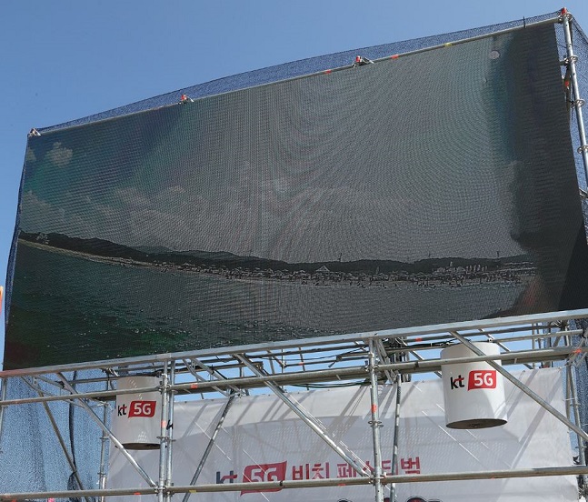 지난 9일 강원도 양양군 서피비치에서 열린 ‘KT 5G 비치 페스티벌 스웩(SWAG)’ 현장에 설치된 대형 전광판에 서핑보드를 타는 영상이 생중계되고 있다.ⓒKT 