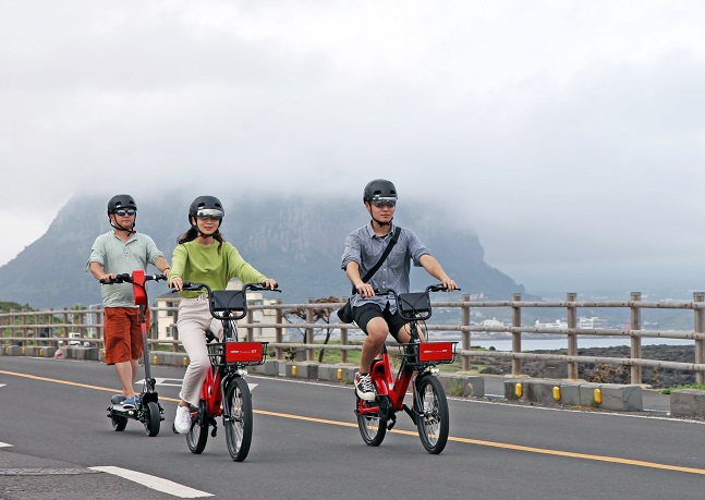 제주도 송악산 지역에서 이용객들이 공유형 전동킥보드와 전기자전거를 즐기고 있다.ⓒ현대자동차
