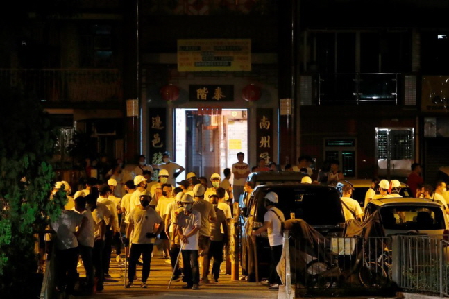 지난달 21일 밤 홍콩 위안랑(元朗) 전철역에서 열린 범죄인 인도법(송환법) 반대 집회 참가자들을 공격한 흰 티셔츠와 헬멧 차림의 남성들이 몰려 있다.ⓒ연합뉴스