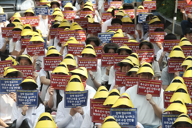 19일 서울 여의도 국민은행 앞에서 열린 '특수교육 대상자 교육권 확보 결의대회'에서 집회에 참가한 학생들이 피켓을 들며 침묵 시위를 하고 있다. ⓒ데일리안 홍금표 기자