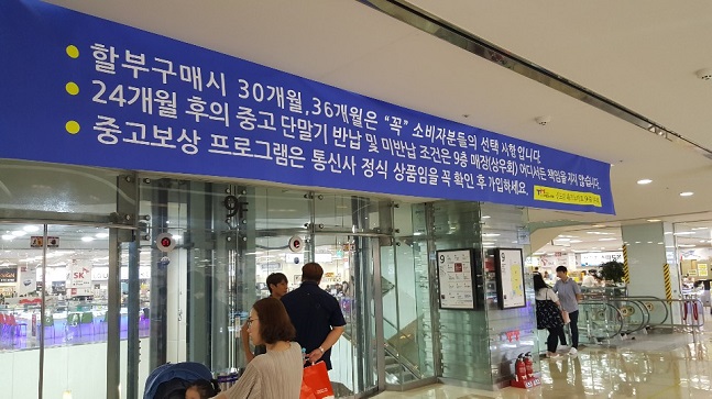 지난 25일 서울 신도림 테크노마트 9층 휴대폰 집단상가에 ‘중고보상 프로그램은 통신사 정식 상품임을 꼭 확인 후 가입하세요.’라는 문구가 적힌 현수막이 걸려있다.ⓒ데일리안 김은경 기자 