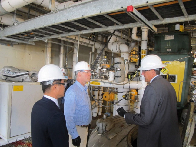 존 믈리나 미국 미시간주 하원의원(가운데)이 스티브 퍼사인 SKSA 공장장(오른쪽)으로부터 PVDC 생산 공정에 대한 설명을 듣고 있다.ⓒSK종합화학