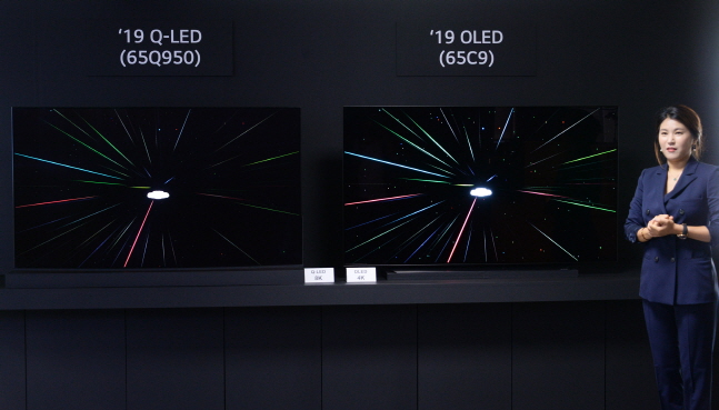 LG전자 한 직원이 17일 서울 여의도 트윈타워에서 개최된 '8K 및 올레드 기술설명회'에서 삼성전자 8K QLED(왼쪽)와 4K 올레드 TV 화질을 비교해 설명하고 있다.ⓒLG전자
