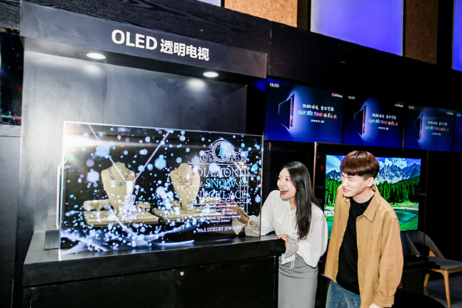 19일(현지시간) 중국 베이징에서 798예술구에 위치한 미파크에서 열린 'OLED 빅뱅 미디어 데이' 행사에서 참석자들이 LG디스플레이의 55인치 투명 유기발광다이오드(OLED) 디스플레이를 관람하고 있다.ⓒLG디스플레이