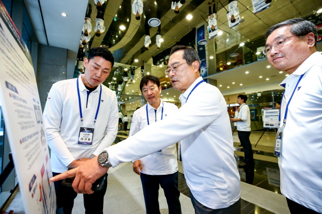구자열 LS그룹 회장(오른쪽에서 두 번째)이 23일 경기도 안양 LS타워에서 개최된 ‘LS T-Fair 2019’에서 우수과제로 선정된 기술에 대한 설명을 듣고 있다.ⓒLS