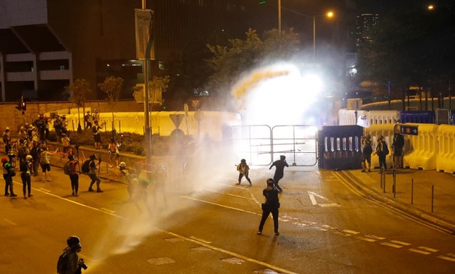28일 홍콩에서 경찰이 자치정부 청사에 화염병을 투척한 시위대를 향해 물대포를 발사하고 있다. 이날 홍콩에서는 우산 혁명 5주년을 기념하는 집회가 열렸다.ⓒ뉴시스