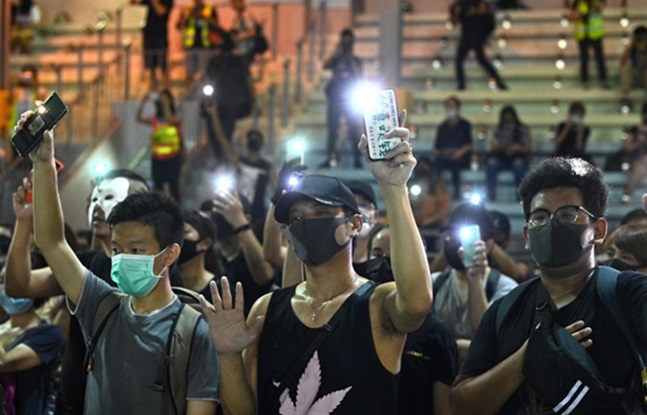 5일 홍콩 삼수이포에서 마스크를 쓴 사람들이 플래시몹에서 스마트폰을 밝히고 있다. ⓒAFP=연합뉴스
