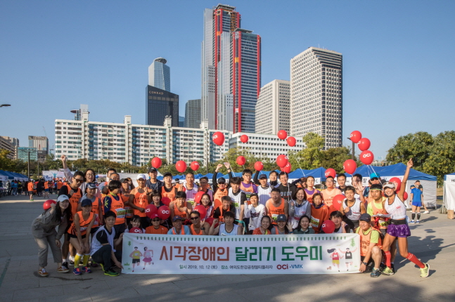 지난 12일 여의도한강공원에서 열린 시각장애인 마라톤 대회에서 참가들과 봉사자들이 기념촬영을 하고 있다.ⓒOCI