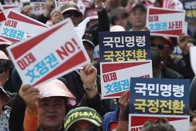19일 오후 서울 종로구 세종문화회관 앞에서 열린 자유한국당 '국정대전환 촉구 국민보고대회'에서 집회 참석자들이 피켓을 들며 구호를 외치고 있다. ⓒ데일리안 홍금표 기자
